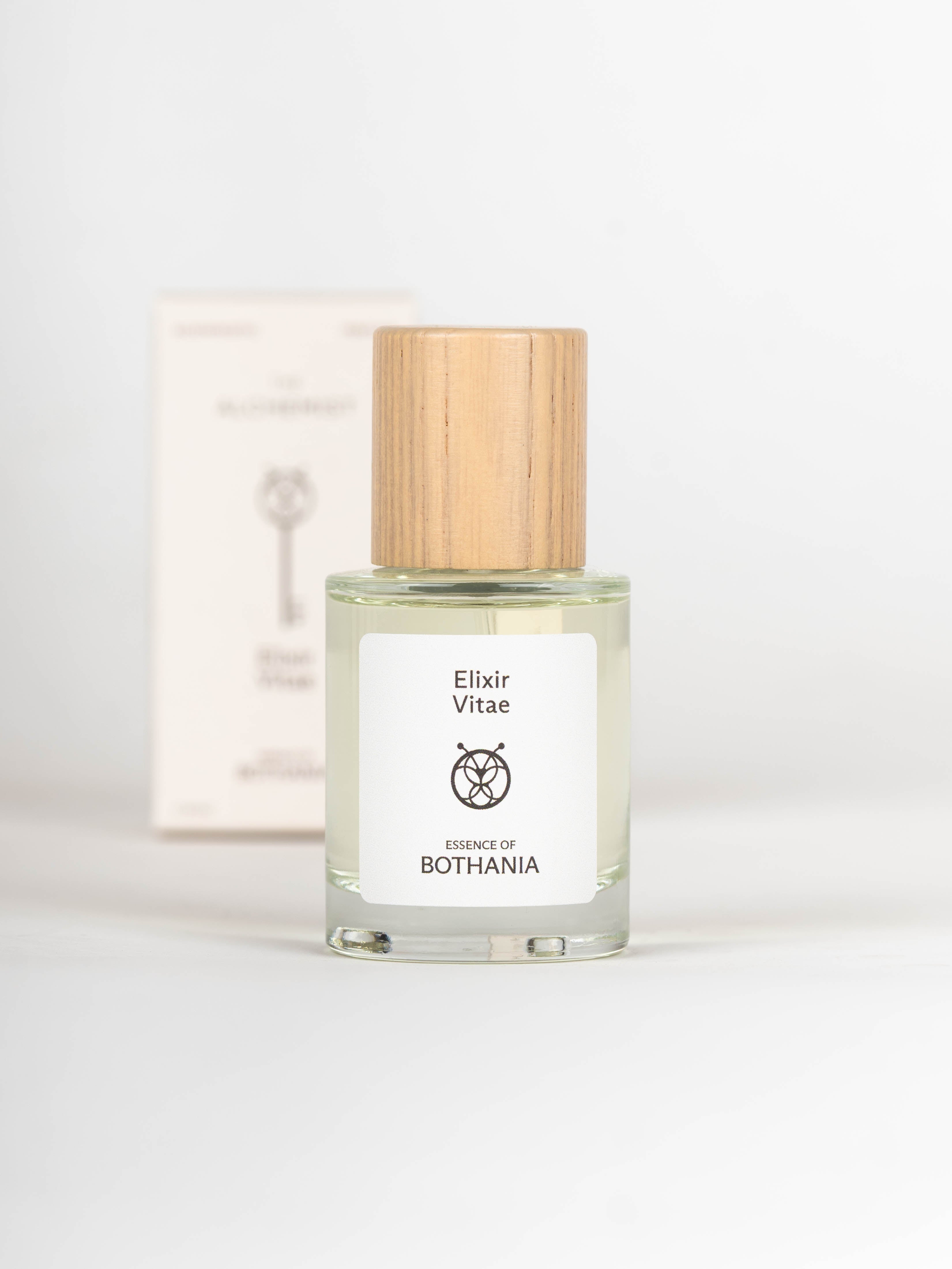 Clear glass bottle with wooden cap labeled 'Elixir Vitae' on a white background