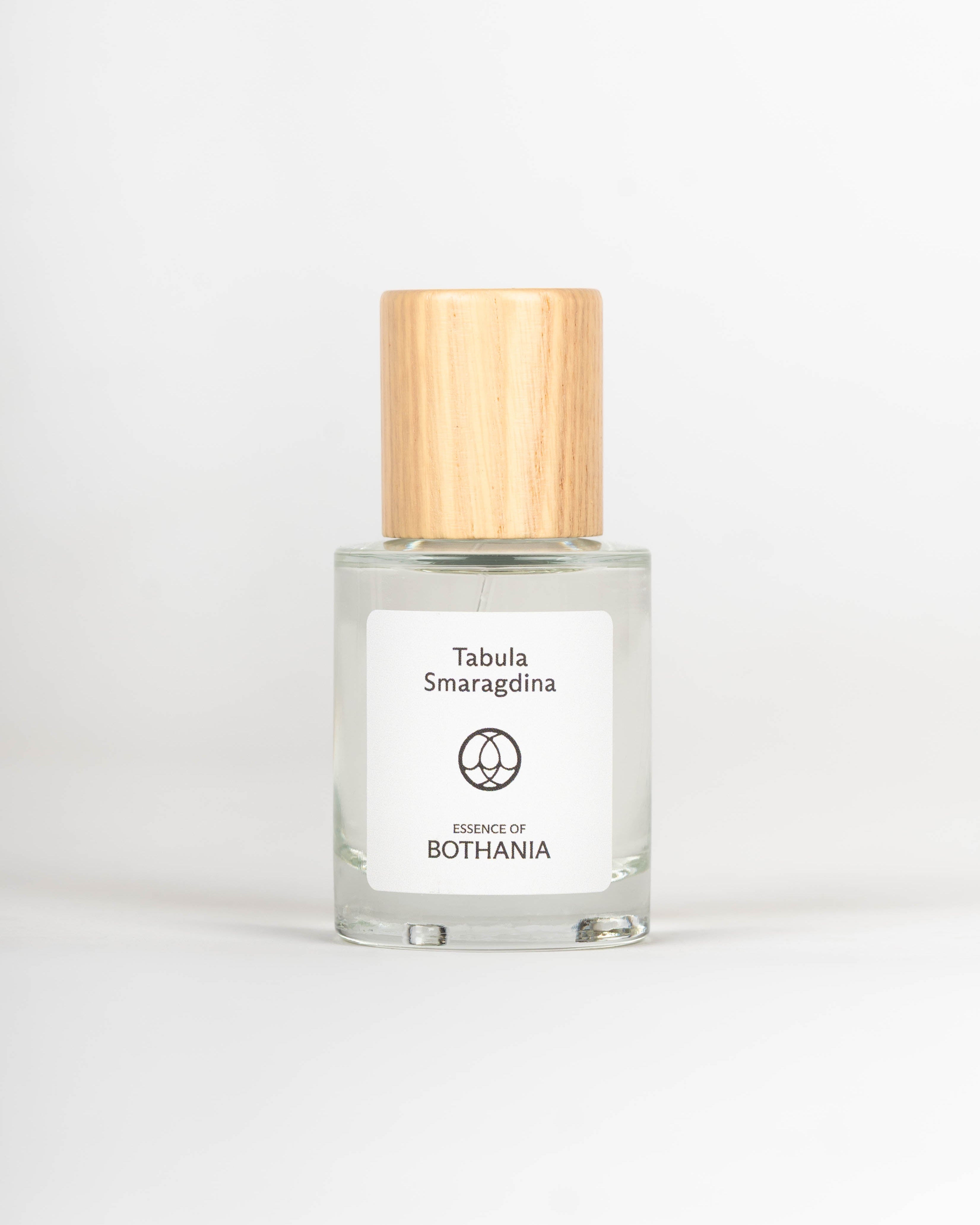 Clear glass bottle with wooden cap labeled 'Tabula Smaragdina' on a white background