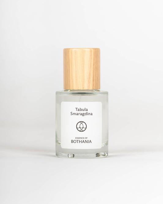 Clear glass bottle with wooden cap labeled 'Tabula Smaragdina' on a white background