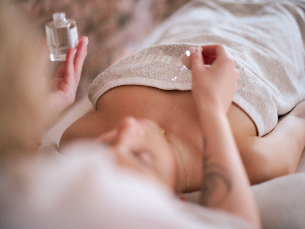 Person applying Elixir to another person's chest with a bottle of House of Bothania Elixir Liquid