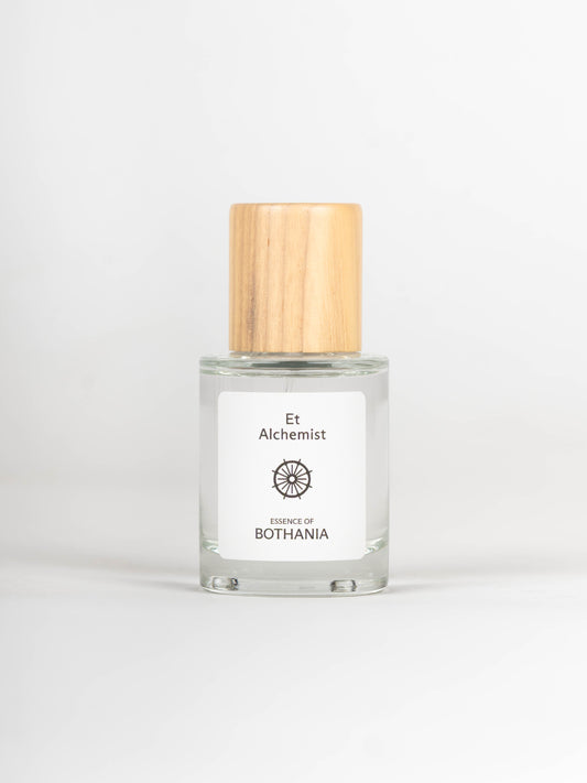 Clear glass bottle with wooden cap on a white background, featuring 'Et Alchemist' branding.